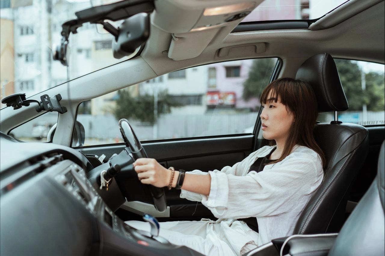Woman driving a right-hand drive exotic car showcasing the Daytona driving experience