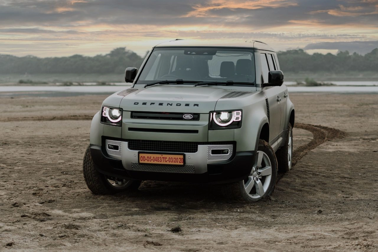 Land Rover Defender SUV on beach at sunset exploring Japanese SUVs from humble beginnings to global icons