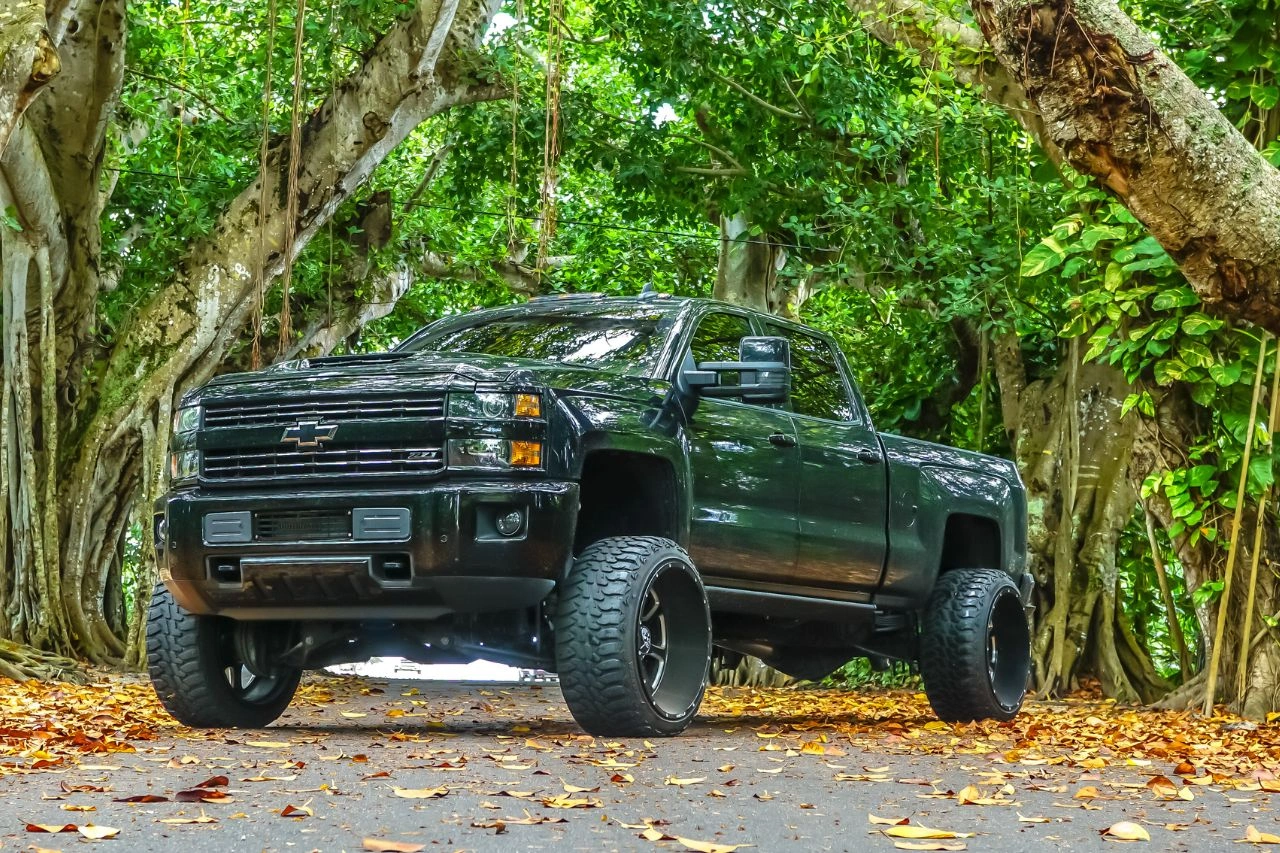 Black Chevrolet Silverado pickup truck in forest autumn setting exploring evolution of pickup trucks global appeal